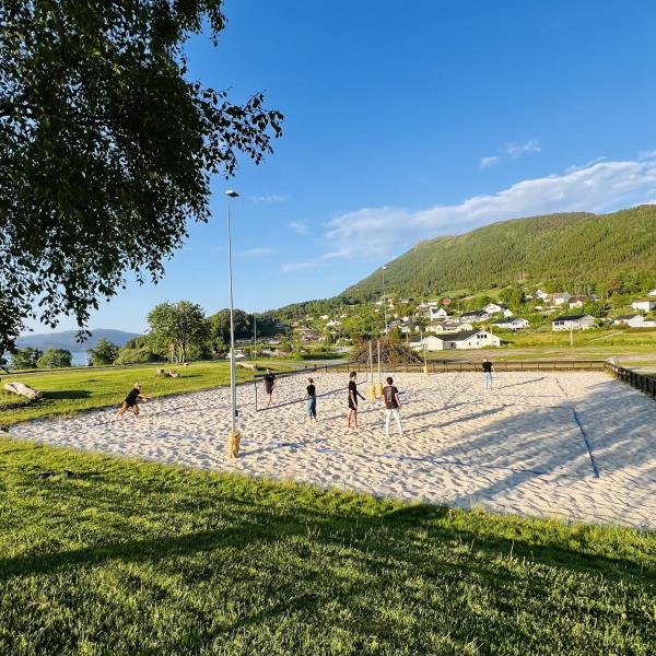 sandvollyballbane med ungdommer som spiller 