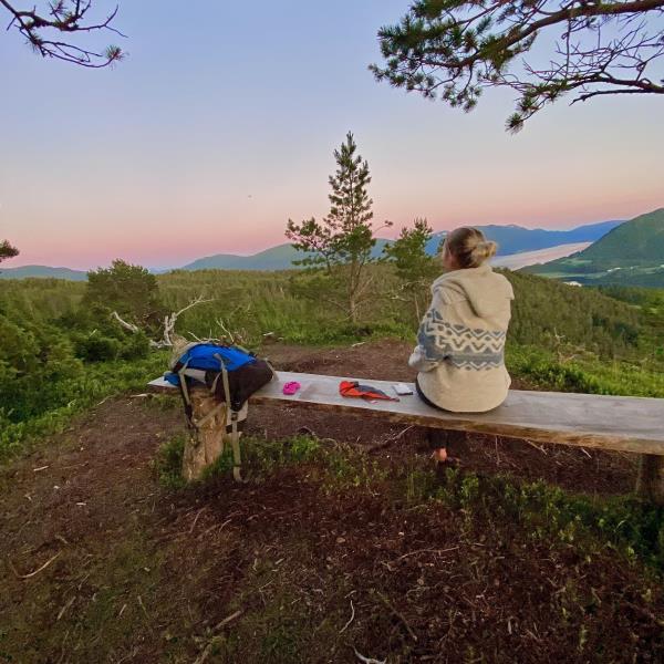 Dame sitter på benk på Høgberget på Bergsøya